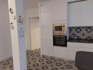 uma cozinha com armários brancos e um micro-ondas em Gulliver em Garda