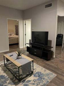 een woonkamer met een tv en een salontafel bij The Ramas in Houston