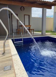 una piscina con una fuente de agua en Casas Amarelas II - Prado BA en Guarani