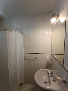 baño con lavabo y cortina de ducha en Hotel Interlagos en San Juan