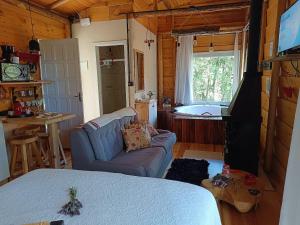 a living room with a couch and a kitchen with a tub at Cabana hidromassagem Morada Alma Gêmea in Bateias de Baixo