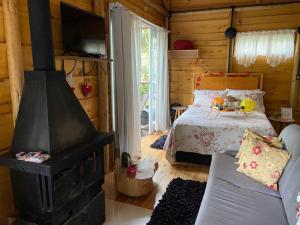 a bedroom with a fireplace and a bed in a log cabin at Cabana hidromassagem Morada Alma Gêmea in Bateias de Baixo