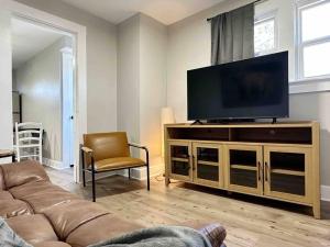 sala de estar con sofá y TV de pantalla plana en Rotherwood Roost / 2BR/1BA Apartment near UE, en Evansville