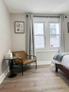a bedroom with a chair and a bed and a window at Rotherwood Roost / 2BR/1BA Apartment near UE in Evansville