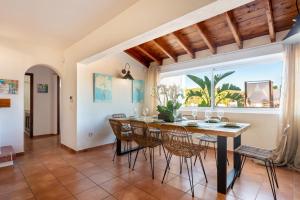 een eetkamer met een tafel en stoelen en een raam bij Bonaire, villa up to 8+2 with pool & views in Ibiza-stad