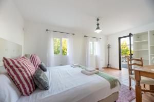 een slaapkamer met een groot wit bed met kussens bij Bonaire, villa up to 8+2 with pool & views in Ibiza-stad