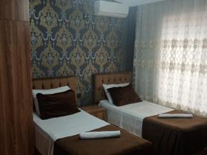um quarto com 2 camas e uma parede com papel de parede em Green villa em Gabala