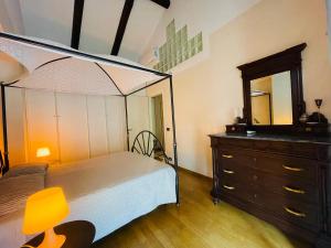 a bedroom with a bed and a dresser and a mirror at Casa Caroli - intera casa ad Alba, LANGHE UNESCO in Alba