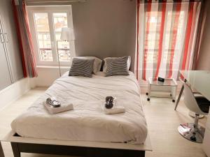 een slaapkamer met een groot bed met twee schoenen erop bij DUPLEX - TERRASSE 2 CHAMBRES CENTRE-VILLE JAUDE in Clermont-Ferrand
