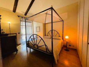 a bedroom with a canopy bed in a room at Casa Caroli - intera casa ad Alba, LANGHE UNESCO in Alba