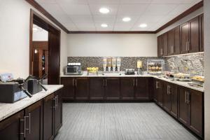 a large kitchen with wooden cabinets and a sink at Homewood Suites by Hilton Manchester/Airport in Manchester