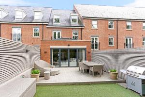 a patio in front of a brick building at Elegant 4-Bed Home,Private Garden,Parking in Virginia Water