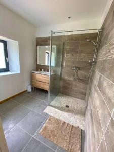 ein Bad mit einer Glasdusche und einem Waschbecken in der Unterkunft Villa de 6 chambres avec piscine privee jardin amenage et wifi a Montpezat de Quercy in Montpezat-de-Quercy