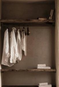 ein Regal mit weißen Bademänteln und Handtüchern darauf in der Unterkunft Slow Refuge in Fanzel