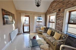 a living room with a couch and a brick wall at The Cliffs of Moher Holiday House in Doolin