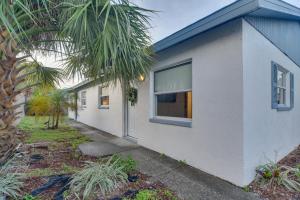 - un bâtiment blanc avec une fenêtre et un palmier dans l'établissement Ideally Located Palm Harbor Condo Walk Downtown!, à Palm Harbor