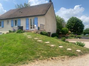 a house with a lawn in front of it at Le Bleu de B. in Saint-Étienne-en-Bresse