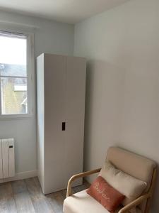 a room with a chair and a cabinet and a window at Appart centre ville Orleans in Orléans