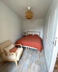 Un dormitorio con una cama roja y una silla. en Appart centre ville Orleans, en Orléans