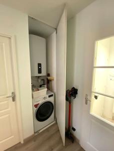 una pequeña cocina con lavadora en una habitación en Appart centre ville Orleans, en Orléans