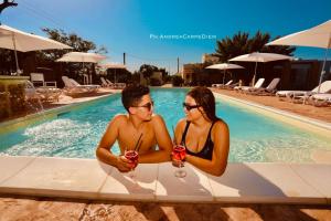 a man and a woman sitting in a swimming pool at B&b Casina Il Mandorlo in Nardò