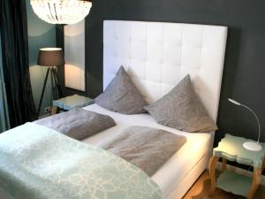 een slaapkamer met een groot wit bed met kussens bij Ferienwohnung Luxus & Lifestyle in Lindau