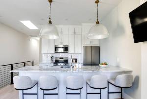 a kitchen with a large white island with bar stools at Vetro Guest House in Richmond