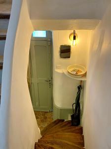 un pasillo con una escalera con una puerta verde y una corbata en La Mansio, en LʼIsle-sur-la-Sorgue