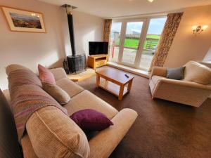 a living room with a couch and a tv at Grange Cottage in Aysgarth