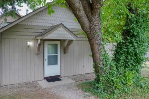 a garage with a white door next to a tree at [S] Cozy Studio for a Peaceful Lawrence Getaway! in Lawrence