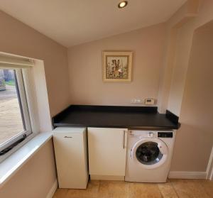eine Waschküche mit Waschmaschine und Trockner in der Unterkunft Grange Cottage in Aysgarth