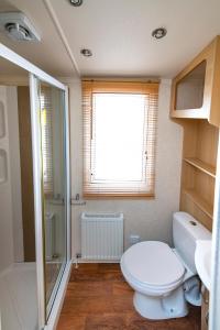 ein Badezimmer mit Toilette und Waschbecken und einem Fenster in der Unterkunft Camping Marina Nowe Guty in Nowe Guty + 30 Fotos