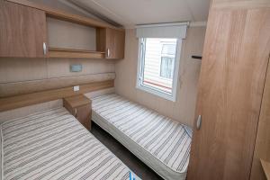 a small room with two beds and a window at Camping Marina Nowe Guty in Nowe Guty