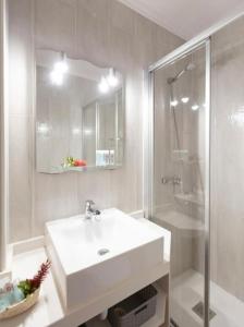 biała łazienka z umywalką i prysznicem w obiekcie El puerto 47, La Savina w mieście La Savina