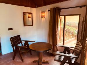 une chambre avec une table, deux chaises et une fenêtre dans l'établissement The Rainforest Hideaway, à Deniyaya
