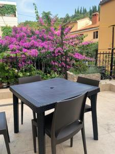uma mesa preta com duas cadeiras e flores roxas em Eco Sea Residence em Piran