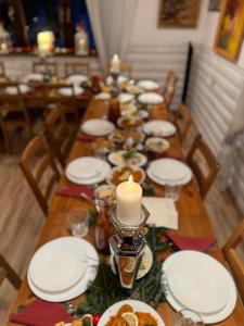 a long table with white plates and a candle on it at ZACISZE in Karłów