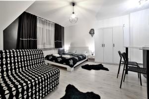 a bedroom with a bed and a couch and a table at Apartamenty czarna perła in Szaflary