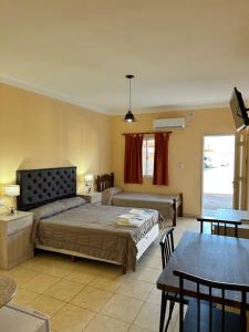 a bedroom with a bed and a dining room at Hotel Valle Colorado in Villa Unión