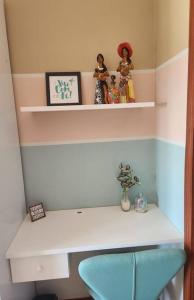 a shelf with dolls sitting on top of a desk at Apartamento Capão da Canoa com garagem in Capão da Canoa