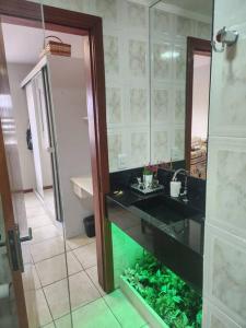 uma casa de banho com um lavatório e um aquário em Apartamento Capão da Canoa com garagem em Capão da Canoa