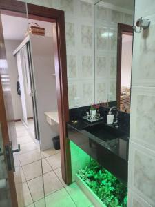 a bathroom with a sink and a fish tank at Apartamento Capão da Canoa com garagem in Capão da Canoa +13 photos