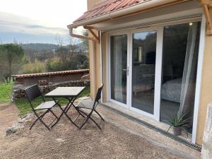 una mesa y sillas en un patio con una puerta corredera de cristal en studio climatisé, en Carnoules