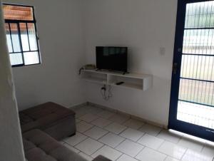 a living room with a tv and a couch at Bangalô Alto da Pedreira in Socorro