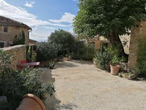 a garden with a bench and trees and plants at Chambre d'hôte in Crillon-le-Brave