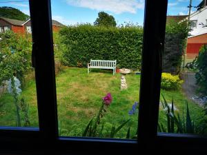 a view from a window of a garden with a bench at Impeccable 1-Bed Lodge in Eastleigh in Eastleigh
