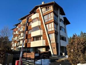 a tall apartment building with at Pine Tree - charming apartment in Bansko