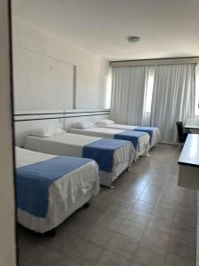uma fila de camas num quarto de hotel em VILLA DEL SOL Hotel em Fortaleza