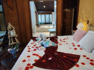 a bedroom with a bed covered in red rose petals at Vista Linda Hotel in Itatiaia