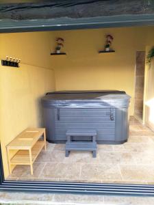 bañera de hidromasaje en una habitación con banco en Maison Provençale Spa Sauna Piscine en Mollégès